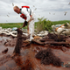 A worker picks up blobs of oil with absorbent snare near the Gulf of Mexico in Plaquemines Parish, Louisiana, immediately following the 2010 accident. Photo: AP